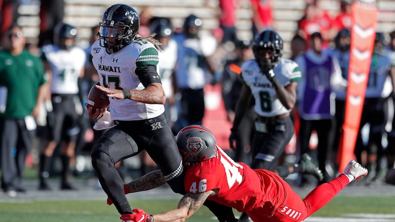 Hawaii quarterback Cole McDonald (13) is tackled by New Mexico linebacker Brandon Shook (46)...