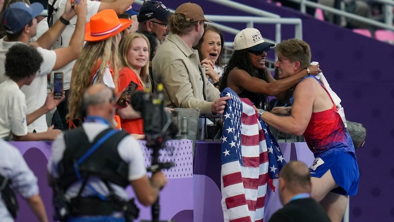 Hunter Woodhall from the U.S. hugs his wife Tara Davis-Woodhall from the U.S., who won the...